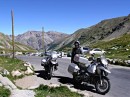 jim col de la cayolle * Jim and bikes with a view to the north from the Col de la Cayolle.  The pass is at 2326 meters (7631 feet).  We were wondering if the tall poles were for the snow-removal process.  The poles are wedged into formed holes, allowing for easy replacement. * 432 x 323 * (62KB)